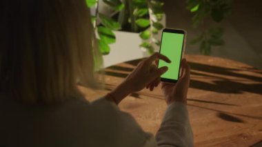 90 fps yavaş çekimde yeşil ekran krom anahtarı olan tek kullanımlık akıllı bir telefona yakın çekim.