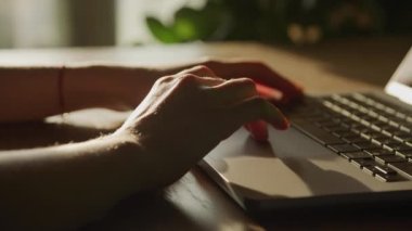 Close up woman hand entering frame and swiping sideways on a laptop computer touchpad in slow motion