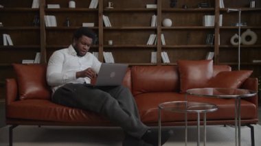 Businessman working on a laptop thinking on a solution in his loft office in slow motion