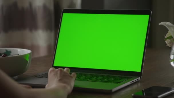 緑の画面のクロマキーとノートパソコンのタッチパッド上の白人女性の手の残りの部分の閉鎖スローモーションでハンドヘルド — ストック動画