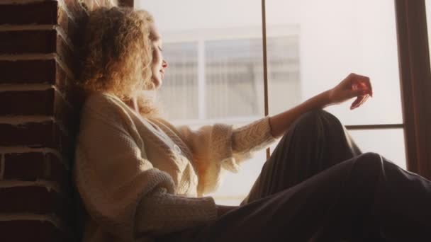 Curly Caucasian Woman Sitting Window Sill Sunset Sunlight — Wideo stockowe