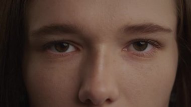 Close up of a caucasian woman open her eyes in 120 fps slow motion in front view