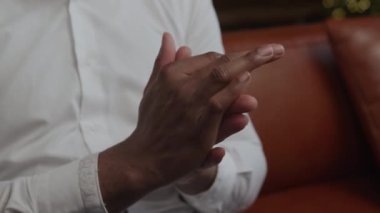 Close up a man rubbing his hands in slow motion indoors