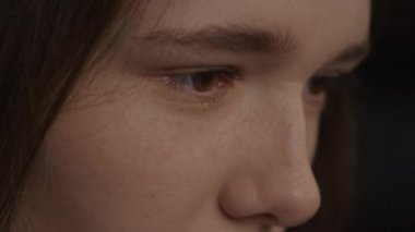 Close up of a caucasian woman open her eyes in slow motion in side view in slow motion