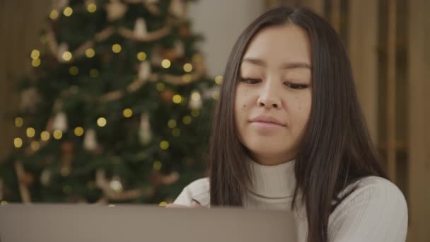 Close Asian Woman Video Call Her Laptop Christmas Tree Background — Stock video