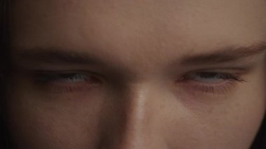 Close up of a caucasian woman raising up her head and open her eyes in slow motion front view