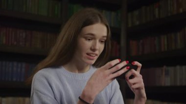 Close up of a caucasian woman winning a game on her smart phone in slow motion indoors