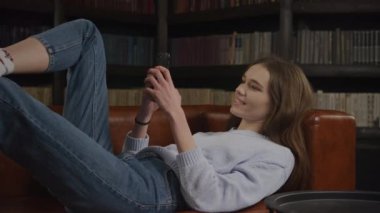 Optical zoom in caucasian woman typing on her smart phone or texting online in slow motion indoors