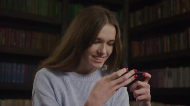 Close up of a caucasian woman playing concentrated game on her smart phone in slow motion indoors