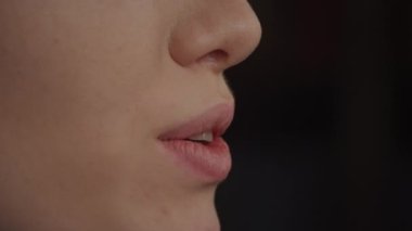 Close up side view of a young adult caucasian woman mouth talking in slow motion in an interview manner