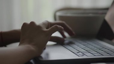 Handheld pivoting around close up of a woman hand browsing swipe and scroll on a laptop touchpad in slow motion