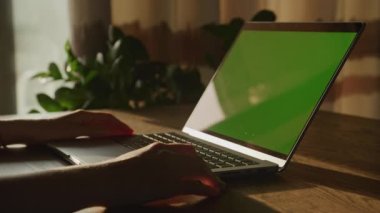 Close up static shot of caucasian woman hands resting on a laptop computer with green screen chroma key in 90fps