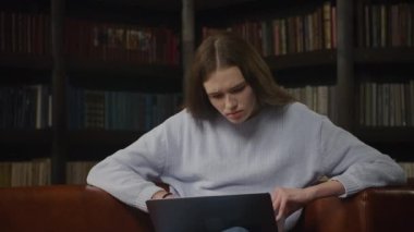 Caucasian woman student working on a laptop confused indoors
