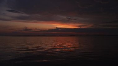 Calm waters and bright skies on a summer dawn on a river
