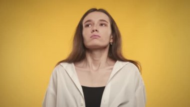 Woman taking a deep breath and exhale on a bright yellow background in slow motion