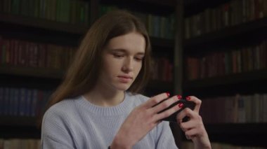 Close up of a caucasian woman playing concentrated game on her smart phone in slow motion indoors