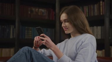 Close up of a caucasian woman browsing on her smart phone online in doubt thinking on a decision in slow motion indoors
