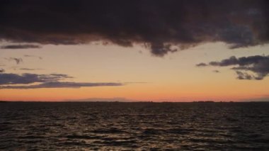 Camera panning over a scenic river with storm sky clouds on a sunset in slow motion outside