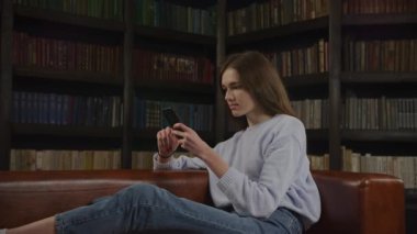 Slow optical zoom in caucasian woman browsing on her smart phone online in doubt in slow motion