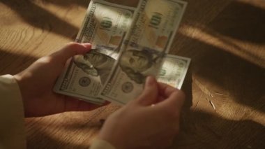 Handheld close up of caucasian woman hands counting money in slow motion 100 dollar bill