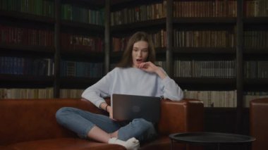 Caucasian student woman waving hand in a goodbye gesture on a video call on her laptop indoors