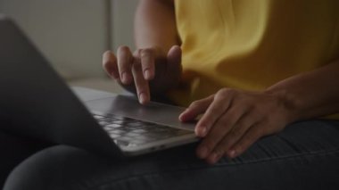 Close up of African Amerian woman hands using laptop touchpad - pinch, swipe and scroll in slow motion handheld