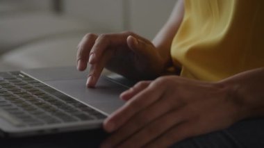Close up of African Amerian woman hands using laptop touchpad - pinch, swipe and scroll in slow motion handheld