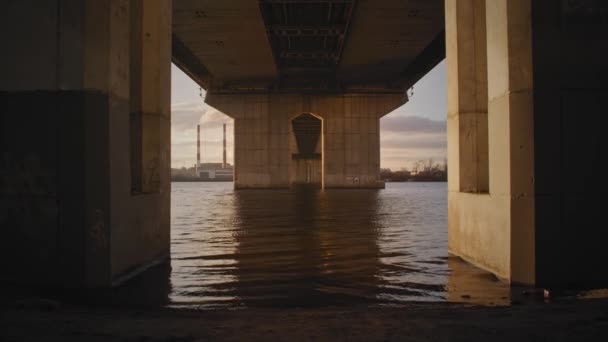 日落时在一座大工业桥下的一条河的底部景观 — 图库视频影像