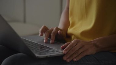 Close up of African Amerian woman hands using laptop touchpad - pinch, swipe and scroll in slow motion handheld