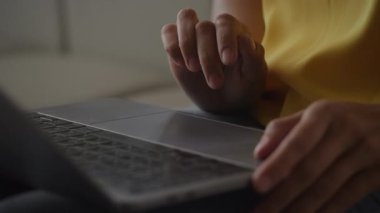 Close up of African Amerian woman hands using laptop touchpad - pinch, swipe and scroll in slow motion handheld