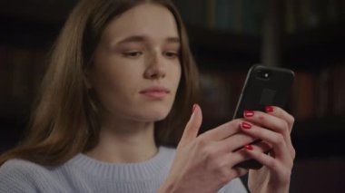 Kafkasyalı kadının kafası karışık. Yavaş çekimde akıllı telefonuna mesaj yazarken kafası karışık.