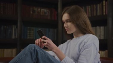 Kafkasyalı bir kadın akıllı telefonuna göz atıyor ve kötü haberleri duygusal olarak alıyor.