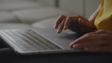 Close up of African Amerian woman hands using laptop touchpad - pinch, swipe and scroll in slow motion handheld