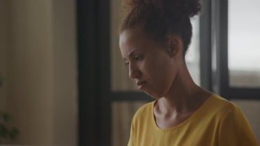 Close up camera pan showing African American woman portrait typing on her laptop keyboard in slow motion indoors
