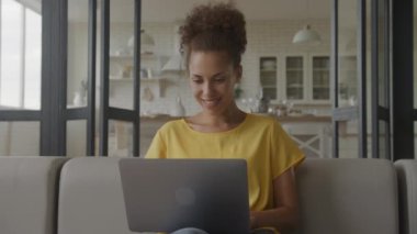 Afrika kökenli Amerikalı bir kadının laptopunda elde ettiği başarıyı yavaş çekimde kutlarken yakın plan.