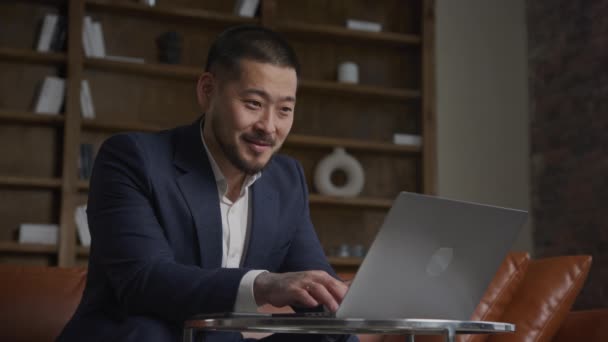 Niski Kąt Ujęcia Azjatyckiego Biznesmena Pracującego Swoim Laptopie Zadowolonego Uśmiechu — Wideo stockowe