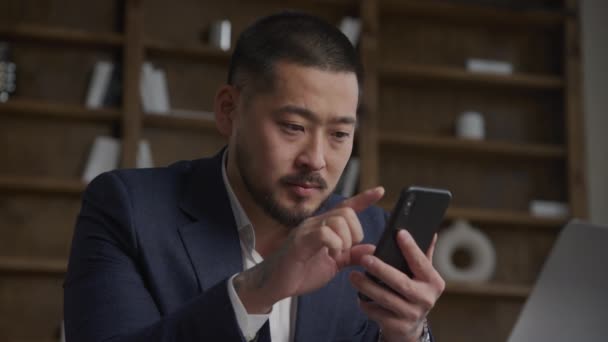 Close Van Een Tattoed Aziatische Zakenman Browsen Zijn Smartphone Met — Stockvideo