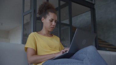 90fps yavaş çekim açık bir ofis el bilgisayarında çalışan Afrikalı bir Amerikalı kadının düşük açılı çekimi.