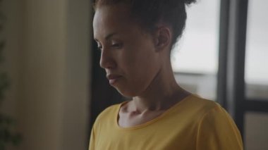 Close up camera pan showing African American woman portrait typing on her laptop keyboard in slow motion indoors