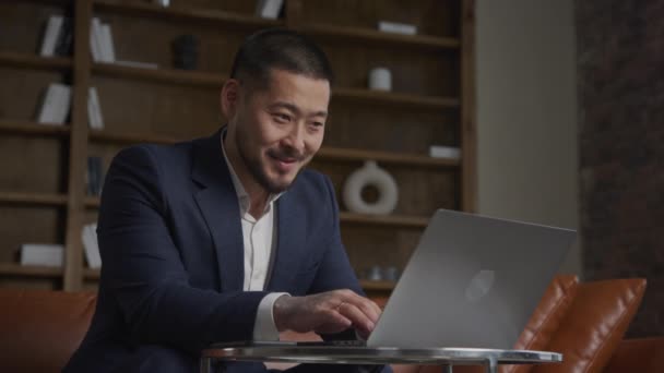 Niski Kąt Ujęcia Azjatyckiego Biznesmena Pracującego Swoim Laptopie Szczęśliwy Uśmiechnięty — Wideo stockowe