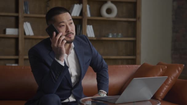 亚洲商人在室内阁楼办公室用智能手机慢吞吞地打电话时得到了一份合同 — 图库视频影像