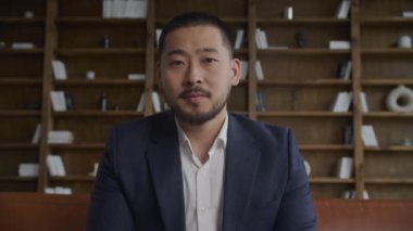 Asyalı bir işadamının çatı katındaki bir video görüşmesinde ağır çekimde selamlama hareketi.