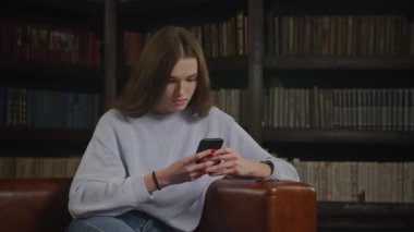 Kafkasyalı bir kadının akıllı telefonuna göz gezdirirken yüz ifadesini yavaş çekimde kapalı tutarken.