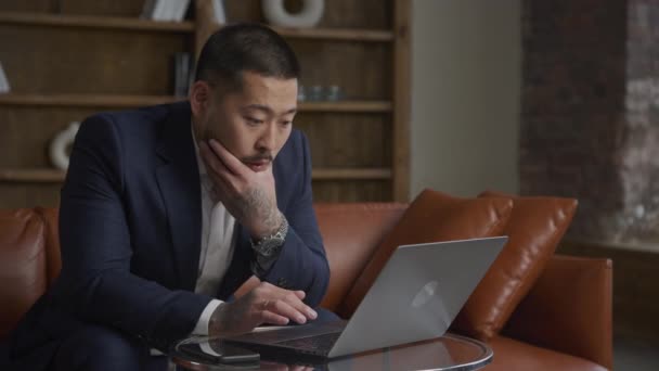 Porträt Eines Schockierten Tätowierten Asiatischen Geschäftsmannes Der Auf Seinem Laptop — Stockvideo