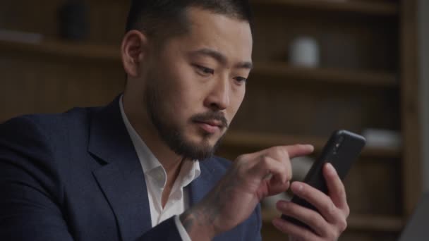 직전의 아시아 사업가 집안에서 동작으로 스마트폰을 검색하고 있습니다 — 비디오
