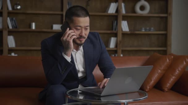 Üzletember Telefonhívás Laptop Számítógépen Dolgozom Felnőtt Tetovált Ázsiai Srác Öltönyben — Stock videók
