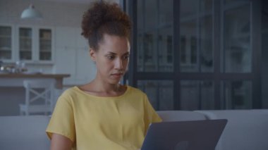 Dizüstü bilgisayarda çalışan kadın. Girişimci Bilgisayarda Yazıyor. El kamerasıyla çekilen Afrikalı Amerikalı çalışanlar yavaş çekimde kapalı alanda çalışmaya odaklanıyor.