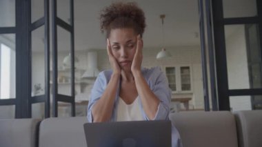 İşkadını Üzüntüsü, Kripto Piyasası Çöküşü, Kötü Haberler. Afro-Amerikalı kadın kendini stresli hissediyor ve dizüstü bilgisayarı üzerinde çalışıyor.