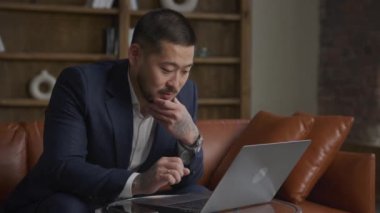 Dövmeli Asyalı İşadamı. Adam laptopta fırsat arıyor. 75 fps ağır çekimde.