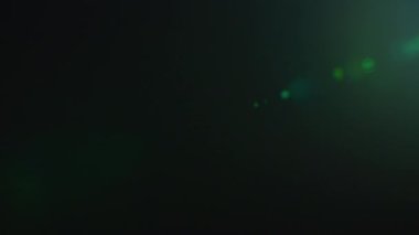 Bir sinemanın gerçek mercek parıltısı, siyah arka plandaki optikler yavaş çekimde mavi kaplamayla çekiliyor.